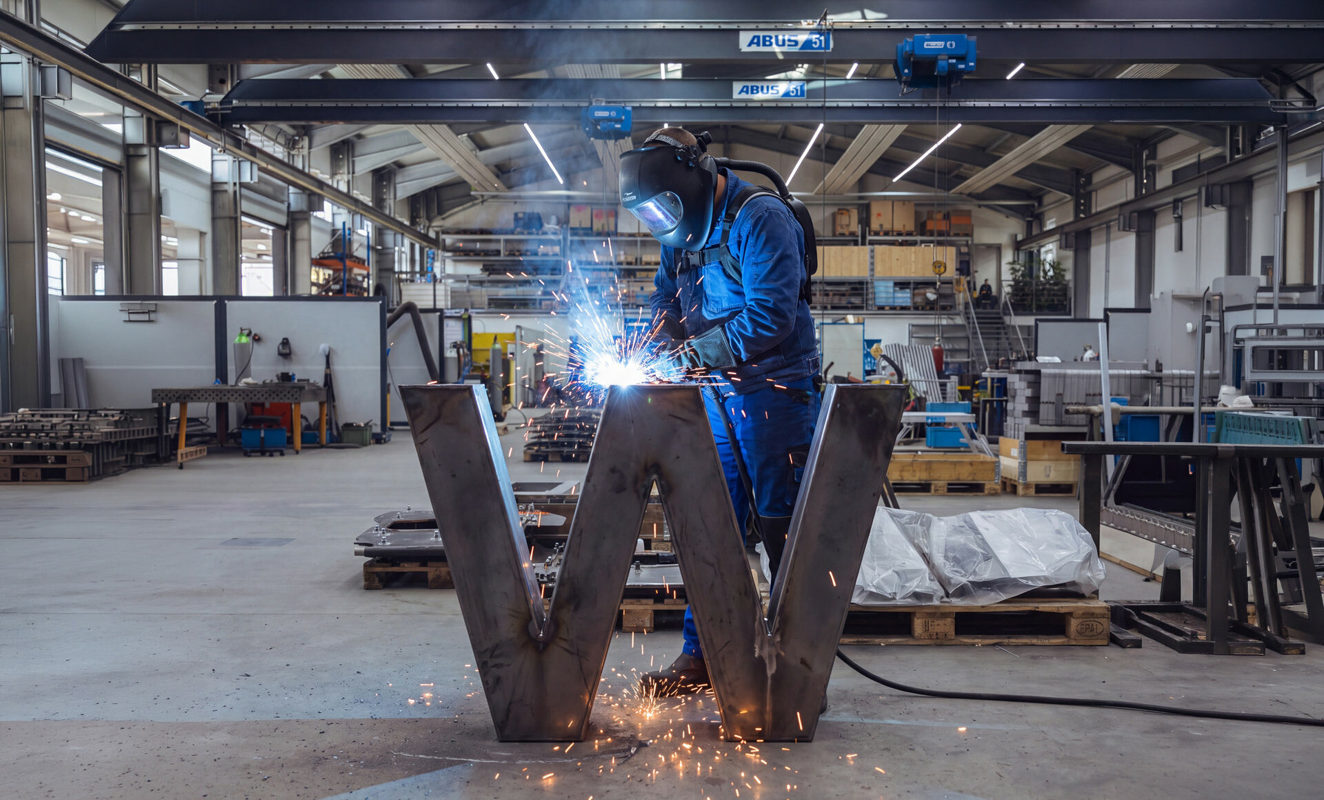 Metallbauer schweißt das Wachinger-W aus Stahl